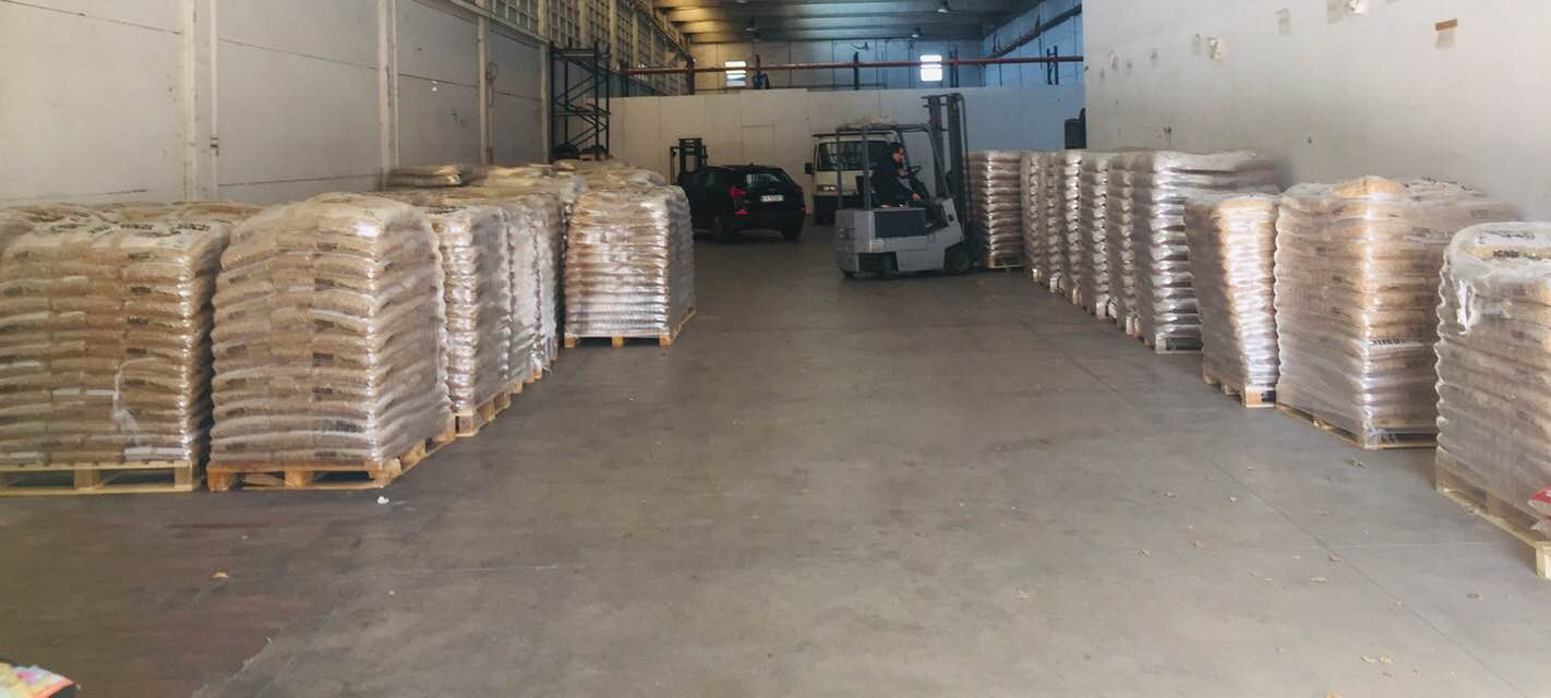 Palletised wood pellet bags arranged along a warehouse aisle
